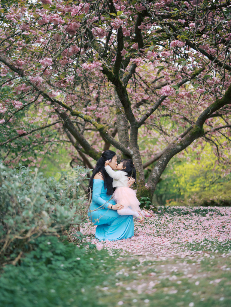 Mom kissing daughter at Seattle cherry blossoms maternity session at UW Arboretum by Seattle Maternity Photographer Tanya Zagumenov