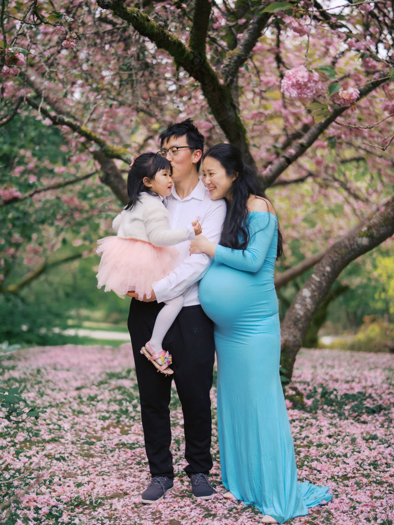 Family snuggling at Seattle cherry blossoms maternity session at UW Arboretum by Seattle Maternity Photographer Tanya Zagumenov