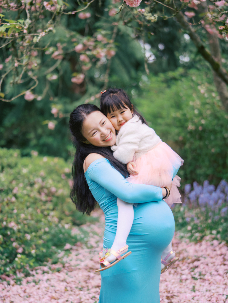 Mom hugging daughter at her Seattle cherry blossoms maternity session at UW Arboretum by Seattle Maternity Photographer Tanya Zagumenov