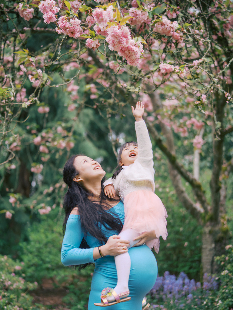 Child reaching for cherry blossoms captured by Seattle cherry blossoms photographer Tanya Zagumenov