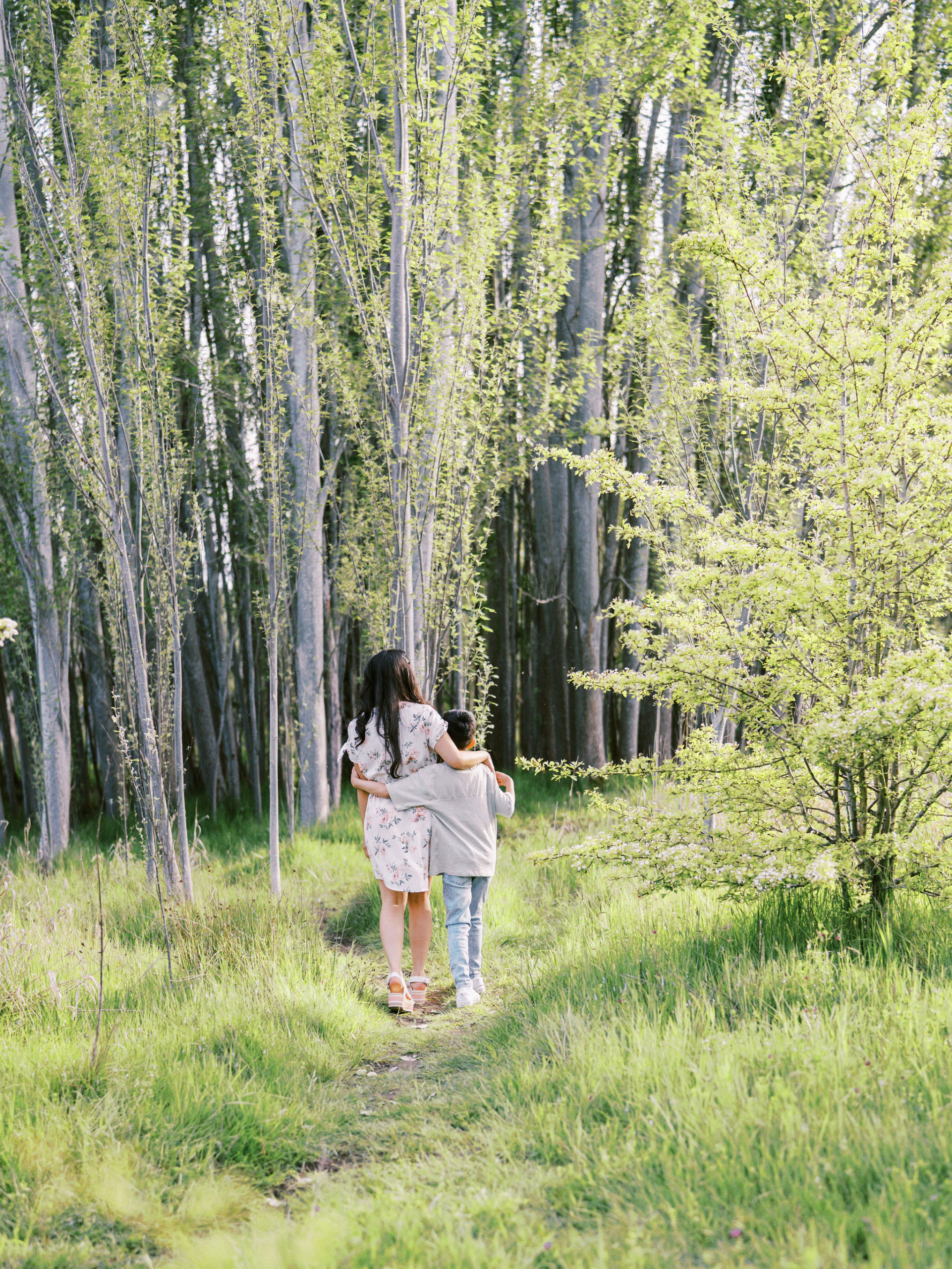 Mother and son walking away on a trail in Seattle park