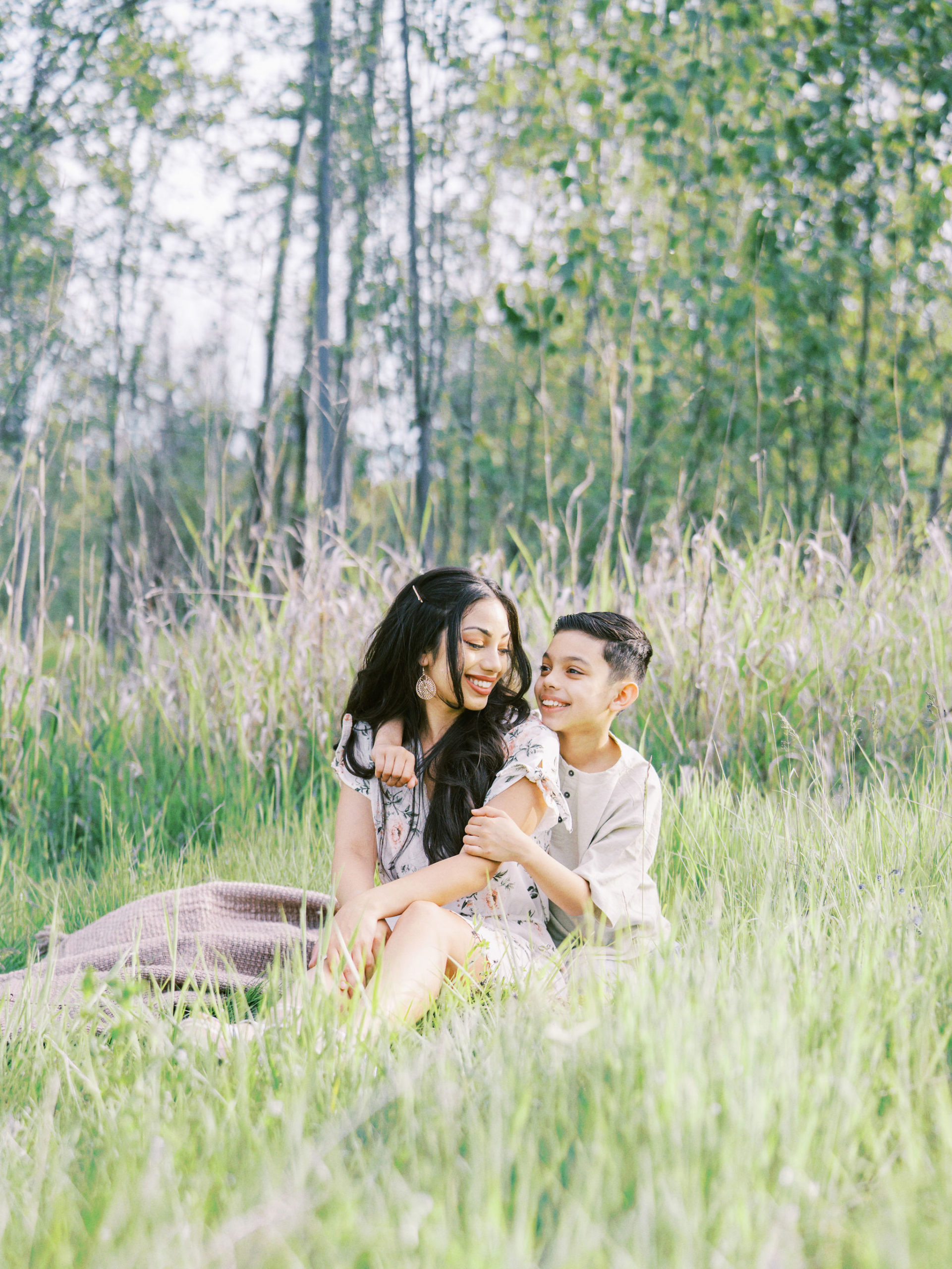 Mother and son sitting on a blanket having a picnic