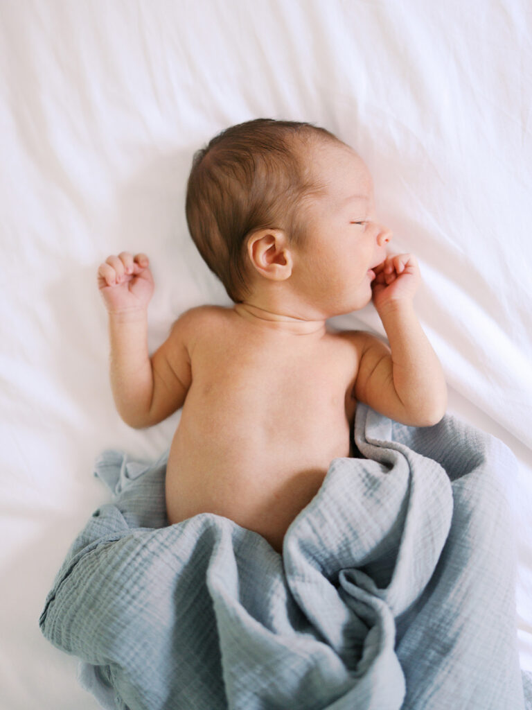 Newborn baby in a muslin swaddle / wrap captured by Seattle newborn photographer Tanya Zagumenov