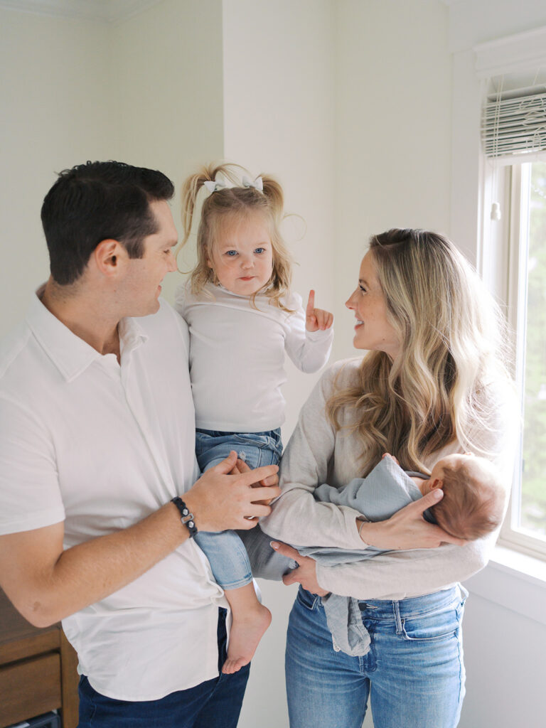 Mom, dad, their toddler daughter and newborn son having fun during a newborn session by seattle newborn photographer Tanya Zagumenov
