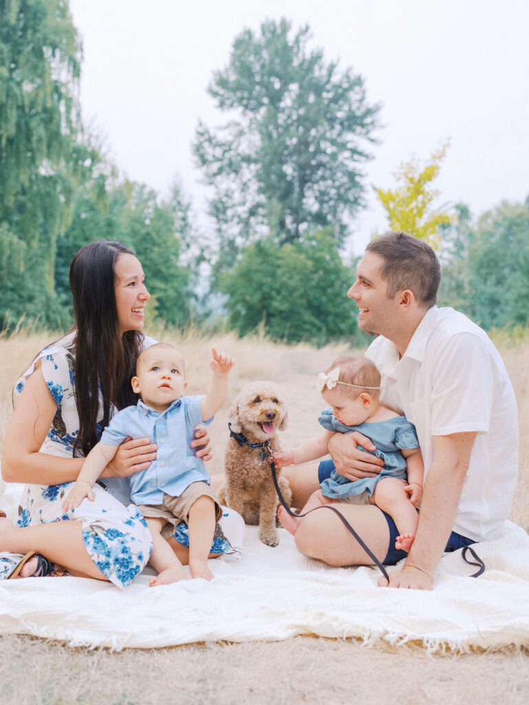 Family (mom, dad and twins) sitting on a blanket in Seattle park by Seattle Family Photographer Tanya Zagumenov