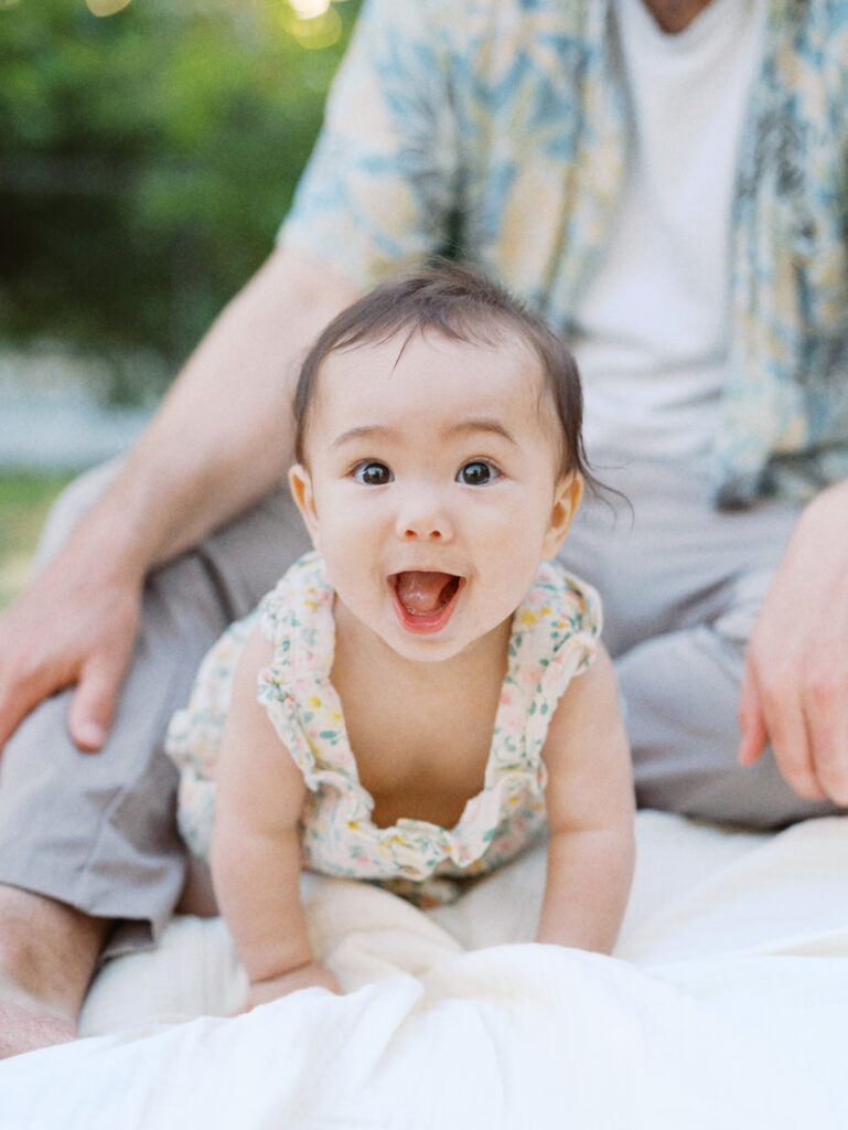 Baby smiling on a blanket during a backyard family session in Seattle