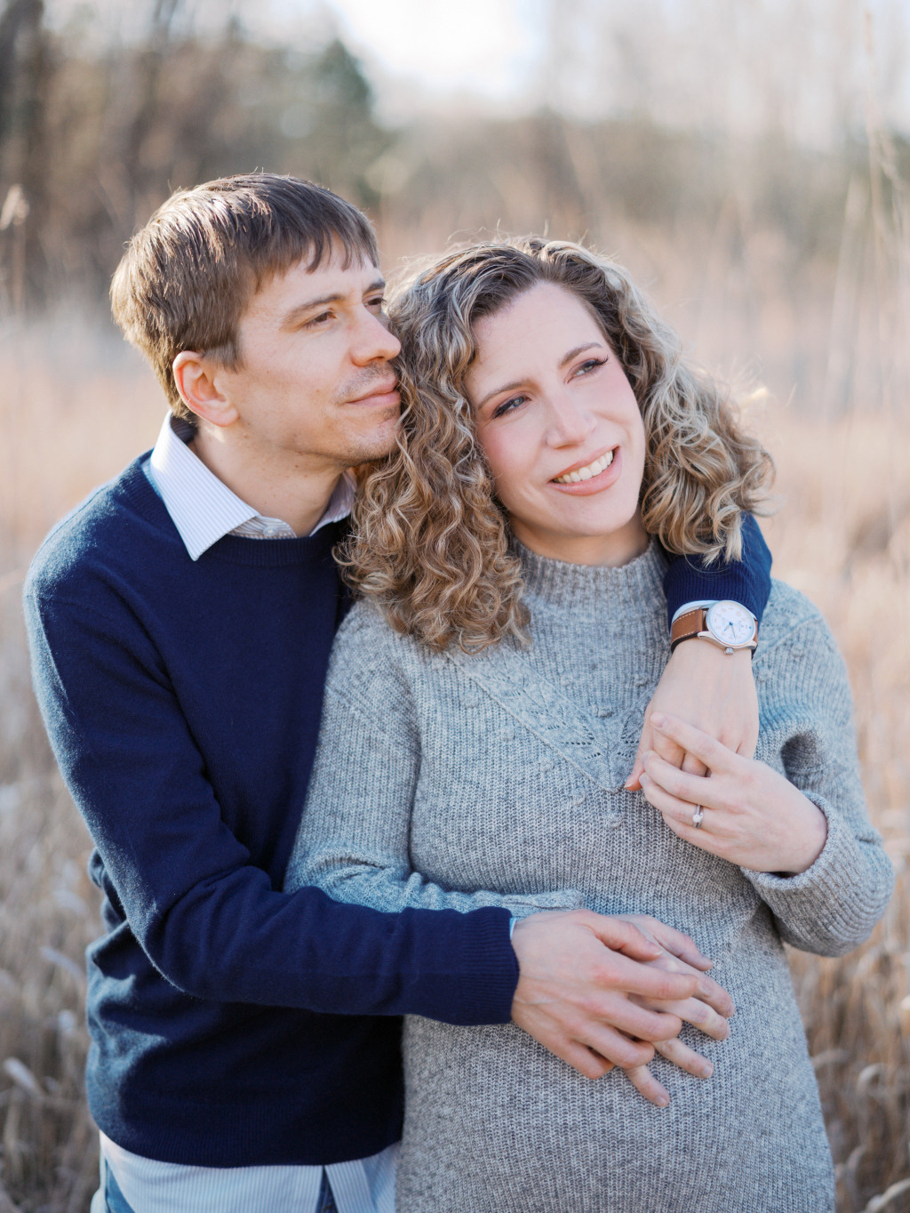 Pregnant woman posing with her husband during a maternity session in a blog post discussing about prenatal massage in Seattle