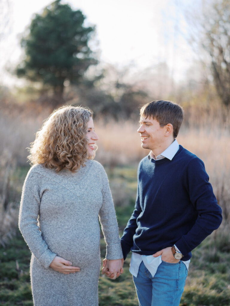 Expecting couple holding hands in a field