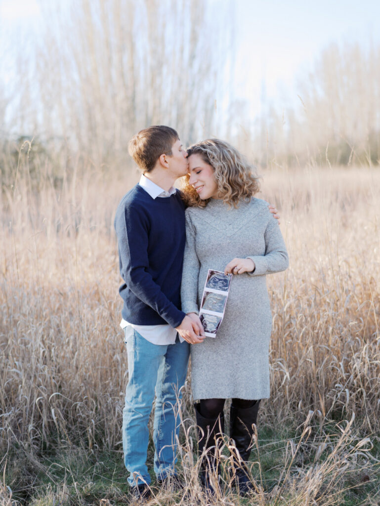 Expecting couple holding an ultrasound photo in a blog post talking about prenatal massage in Seattle