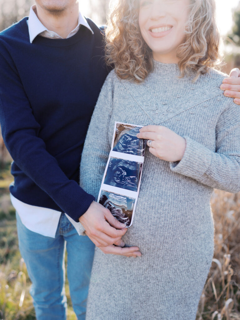 A close-up of an expecting couple holding an ultrasound photo