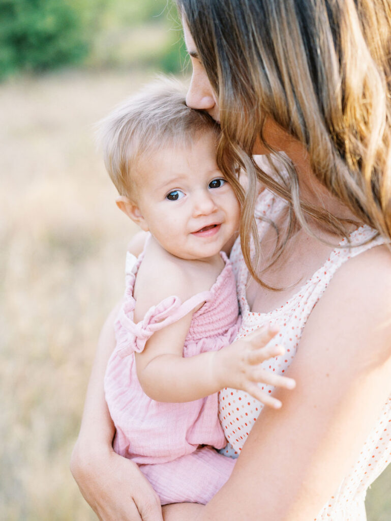 Baby looking cute in her Seattle baby store outfit being held by mom
