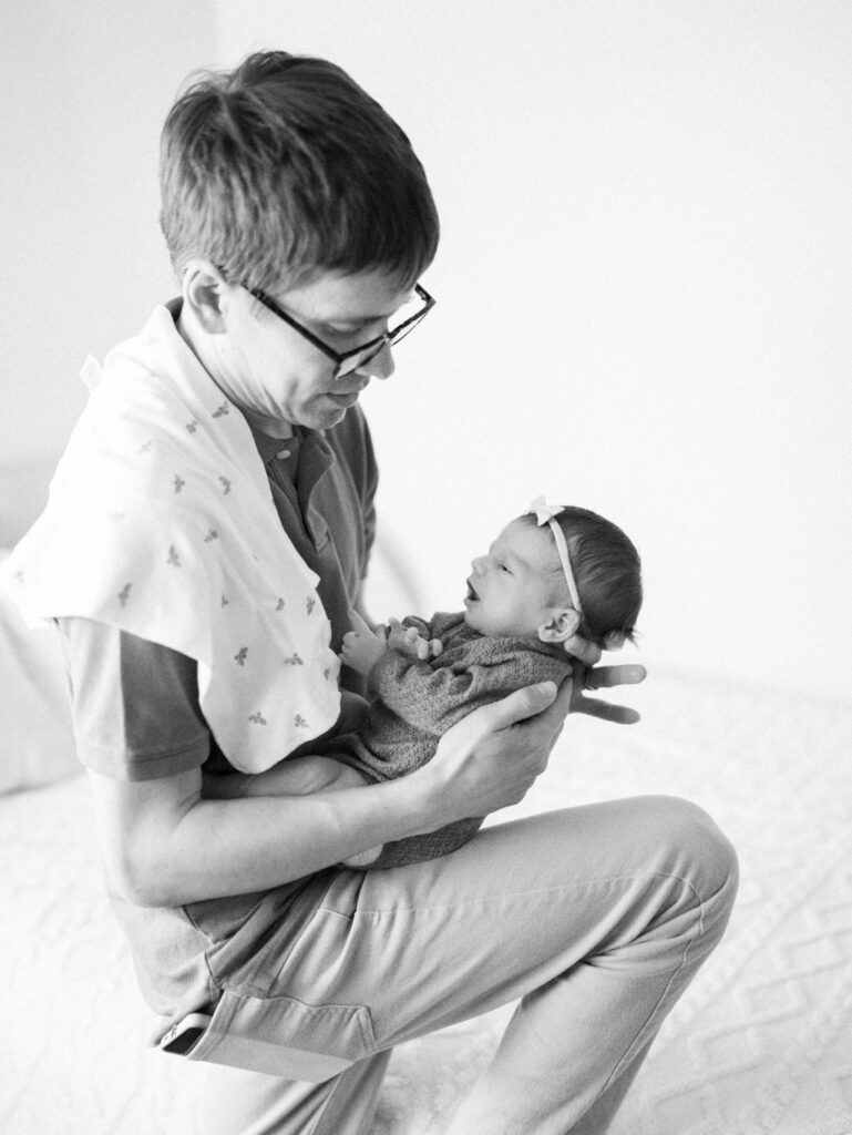 black and white image of dad feeding and burping the baby