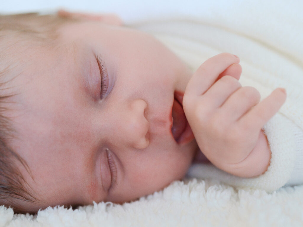 Newborn baby girl sucking on her hand in a seattle birth center