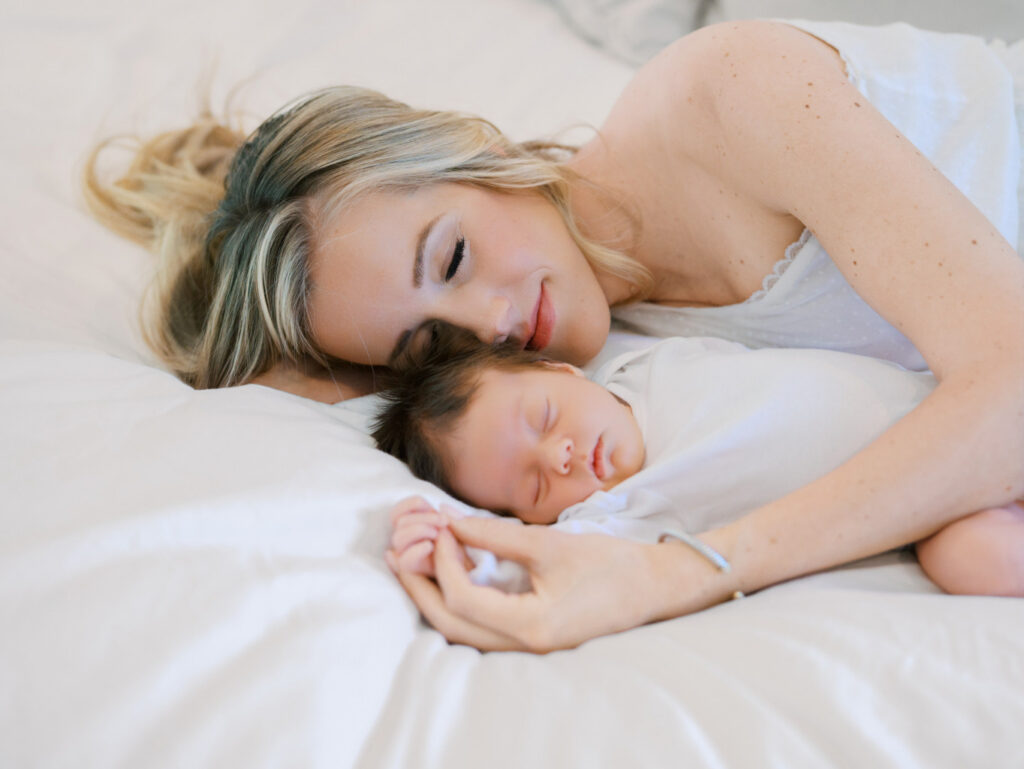 Mom laying on the bed with her newborn daughter
