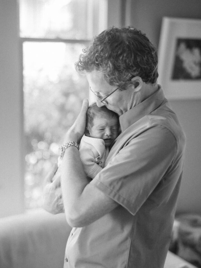 Black and white image of dad cuddling his baby boy after a Seattle birthing center birth