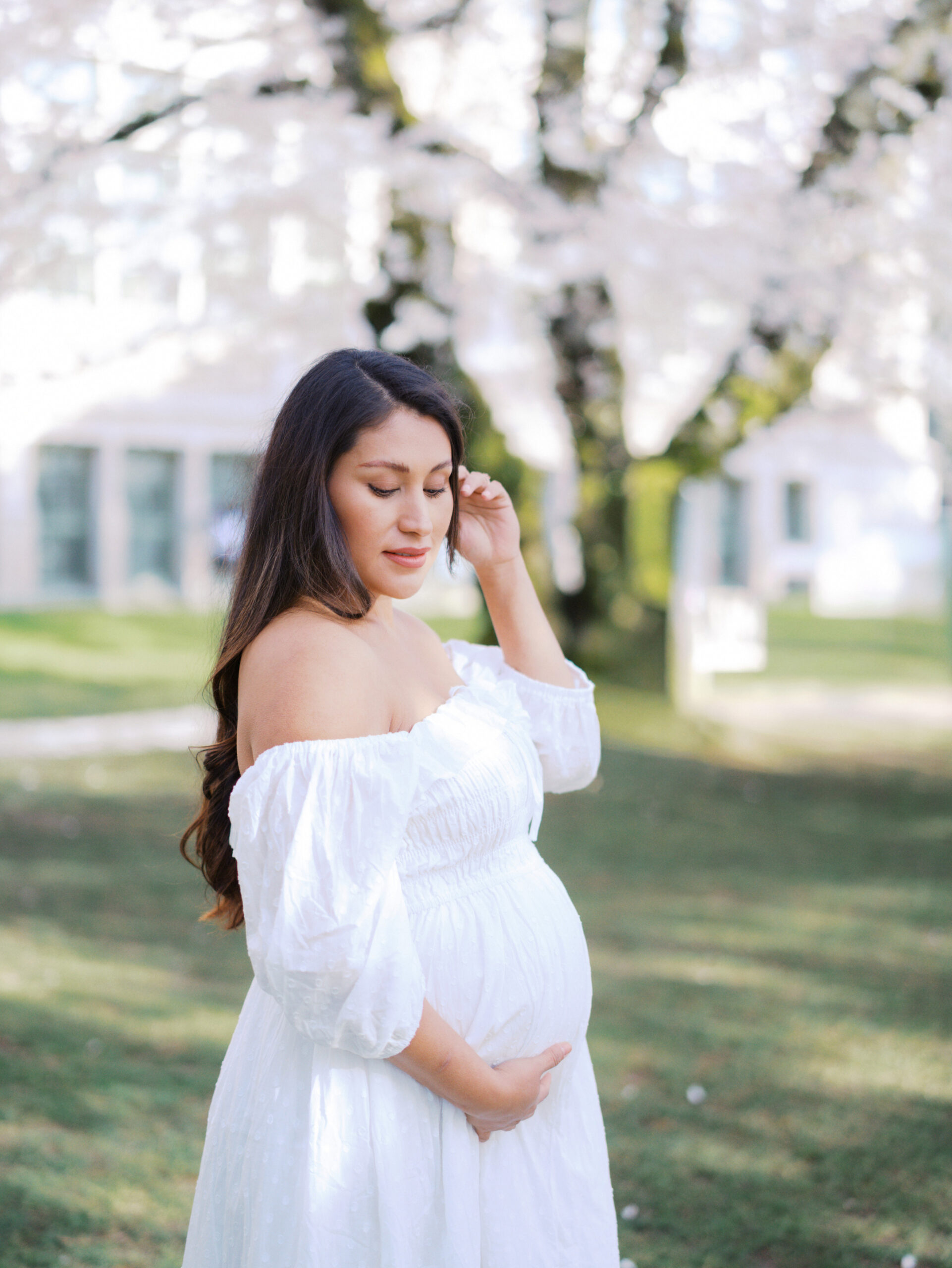 Pregnant woman wearing a white dress contemplating getting her Seattle 3D Ultrasound