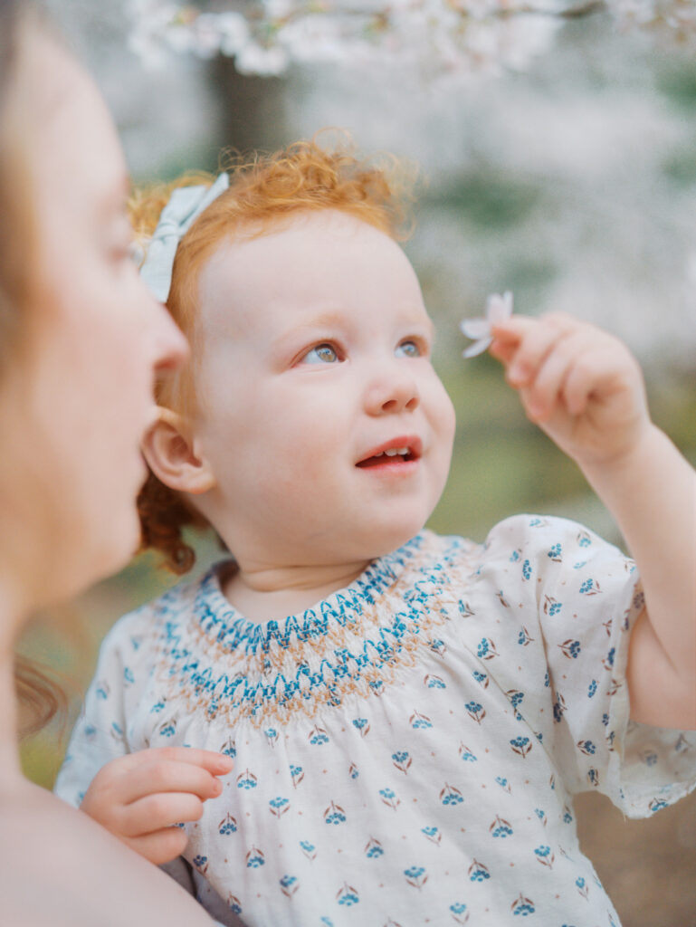 Toddler girl smelling a flower